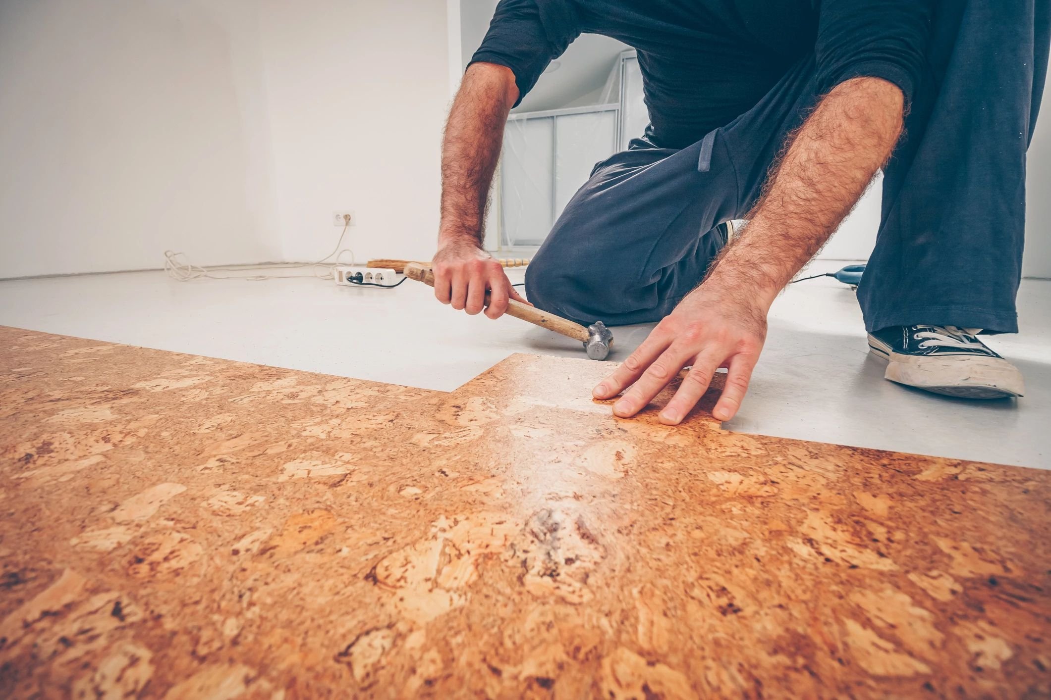 Person installing cork flooring from Perkins Carpet Co in Conroe, TX